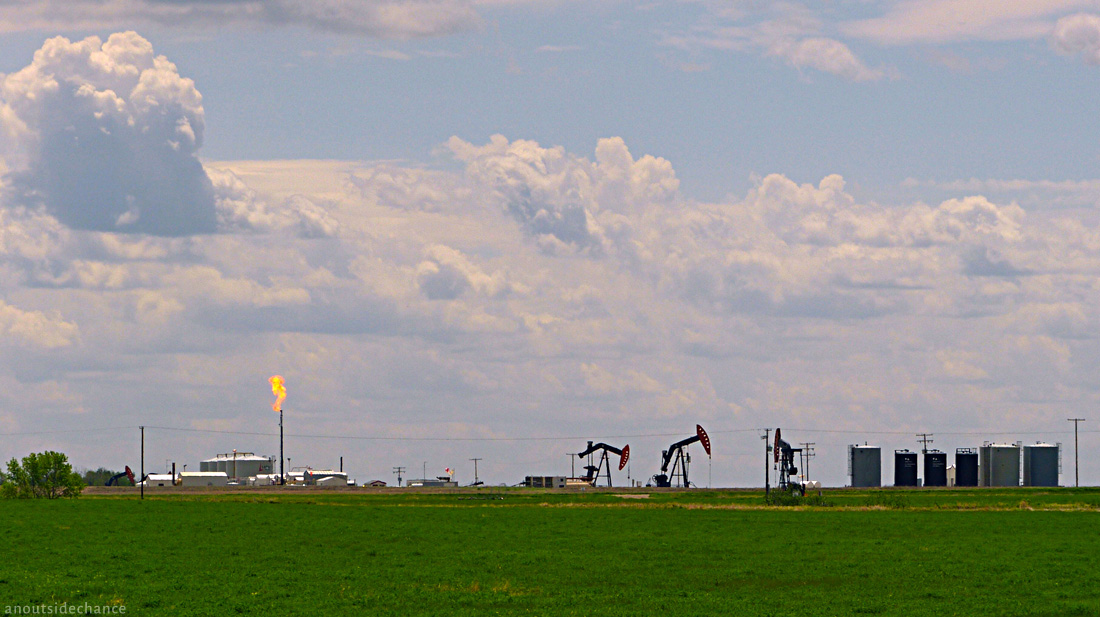 Oil wells with gas flare, southern Saskatchewan.